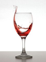 swashing glass of red wine isolated on white background