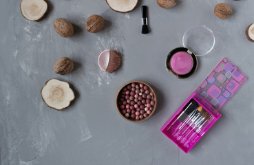  A set of pink makeup brushes with blush on a gray phon