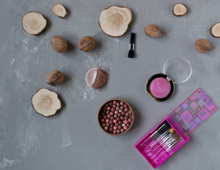  A set of pink makeup brushes with blush on a gray phon