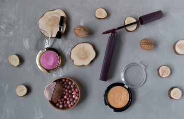 Fototapeta na wymiar Makeup set on a gray background among the round wood