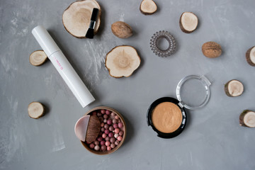  Makeup set on a gray background among the round wood