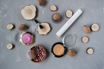   Makeup set on a gray background among the round wood