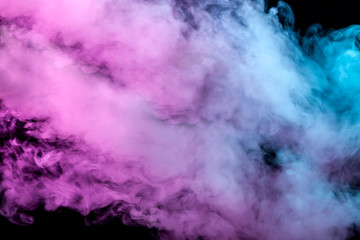 Translucent, thick smoke, illuminated by light against a dark background, divided into three colors: blue, green and purple, burns out, evaporating from a steam of vape.