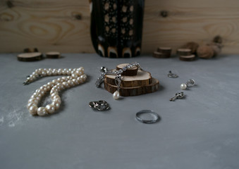  Silver jewelry on a gray background with a string of pearls
