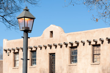 Fototapeta na wymiar Street lamp and traditional Southwestern styled house in Taos historic district, New Mexico, USA