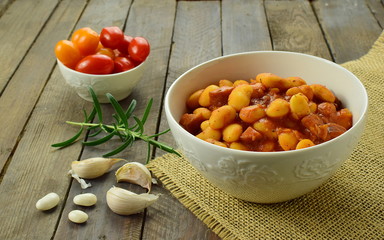sate cooked beans in a bowl with tomatoes, rosemary and garlic
