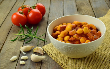 sate baked beans in a porcelain bowl  with tomatoes