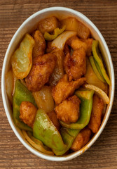 sweet and sour chicken on a wooden table