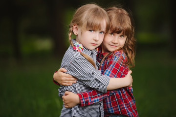 two girls hugging each other on green