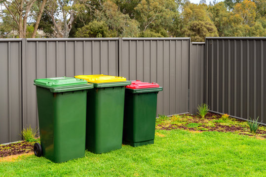 Australian home rubbish wheelie bins set on back yard
