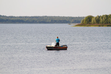 Fototapeta na wymiar A fisherman with a fishing rod on a boat