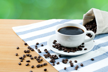 cup of coffee and beans on wooden table