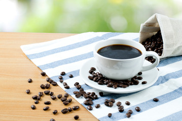 cup of coffee and beans on wooden table
