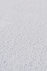 Snow surface lumps. Texture, background. Snow on a cloudy day. Vertical frame.