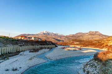 mountain river on the background of mountains and a little village