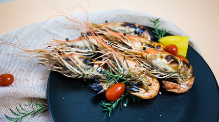 Grilled orange shrimp on a black plate