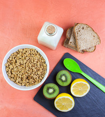 ISTA CENITAL DE DESAYUNO CON CEREALES, LIMON, KIWI, PAN RÚSTICO Y BOTELLA DE CRISTAL DE LECHE