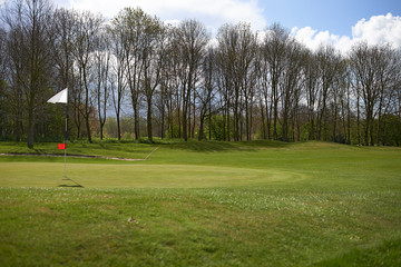 Landscape of a beautiful golf course with greens and holes and bunkers