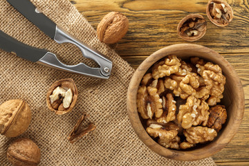 Walnut, shell cleaning process. Natural product on a wooden table. Rustic style.