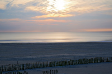 Long exposure of the clouds moving along the beach creating lines in the sky