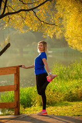 Image of young girl stretching in summer park