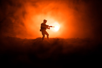 Fototapeta na wymiar Military soldier silhouette with gun. War Concept. Military silhouettes fighting scene on war fog sky background, World War Soldier Silhouette Below Cloudy Skyline At night.