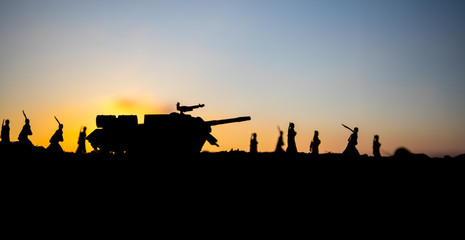 Fototapeta na wymiar War Concept. Military silhouettes fighting scene on war fog sky background, World War Soldiers Silhouettes Below Cloudy Skyline at sunset. Attack scene. Armored vehicles.