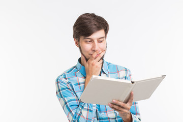 Education, leisure and people concept - young beard man reading a book and surprised