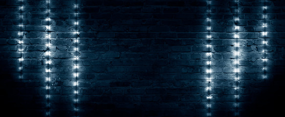 Old brick wall, dark room with brick wall, rays of searchlight light, illuminated night lights on...