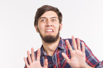 People, expression and gesture concept - young man showing stop gesture on white background