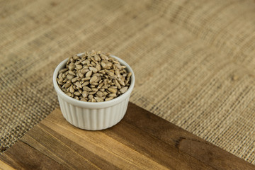 Fototapeta na wymiar sunflower seeds in white bowl on wooden table