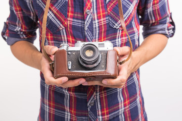 Vintage, photographer and hobby concept - close up of retro camera in man's hands over the white background