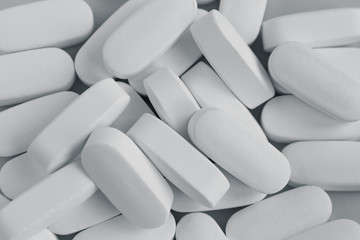 White pills on white background. top view