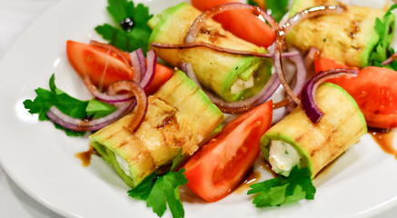 appetizer at the Italian restaurant: zucchini rolls grilled with mozzarella, tomatoes, red onions and balsamic vinegar, Italian cuisine, mediterranean diet, banquet