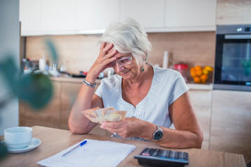 Stressed senior woman is doing banking and administrative work at home