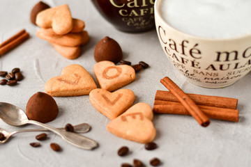 two cups of coffee and cookies in the shape of hearts, on the cookie letters LOVE. the concept of a gift for Valentine's day on February 14. selective focus