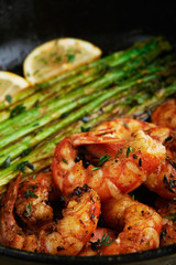 fried langoustines with asparagus decorated with lemon slices. roasted king prawns tiger shrimps with green garnish