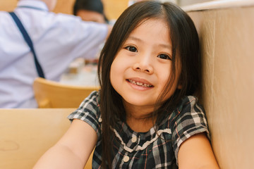 Cute Little Asian Girl in Restaurant.