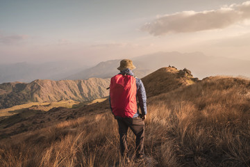 Young man traveler with backpack trekking on mountain, Adventure travel lifestyle concept