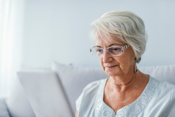 Porrtait of senior woman using electronic tablet at home
