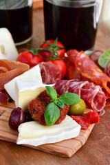 Traditional italian antipasto with prosciutto, cheese, olive and sausage, selective focus