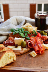 Traditional italian antipasto with prosciutto, cheese, olive and sausage, selective focus