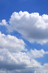 Naklejka na ściany i meble Vertical image of white fluffy clouds floating on vibrant blue sky 