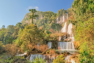 Thi Lo Su Waterfall (Umphang), beautiful silky water flowing from top of green mountain around with green forest and blue sky background, the largest waterfall in Thailand, Umphang, Tak, Thailand.