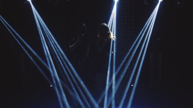 Young sexy profile of a womans with a beautiful face and lips. Girls singing to the microphone in a studio. Black and white