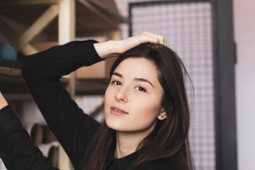 Fototapeta premium young pretty girl, student, hipster, doing a startup, working in an office or library, browsing dusty shelves with cardboard boxes in typography