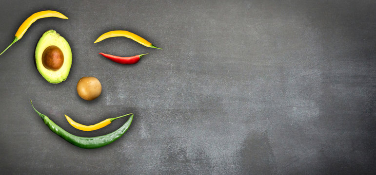 l&auml;chelndes emoji aus gem&uuml;se isoliert auf schwarzer kreidetafel, vegetarische ern&auml;hrung hintergrund konzept mit werbefl&auml;che