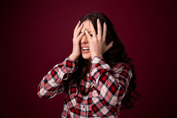 oung woman covering her eyes isolated on color background