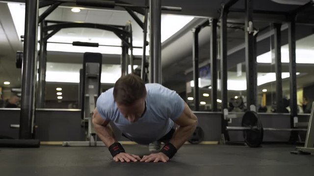 Image of an attractive man doing push-up at the gym.