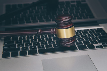 Wooden law gawel on laptop keyboard, judgement concept